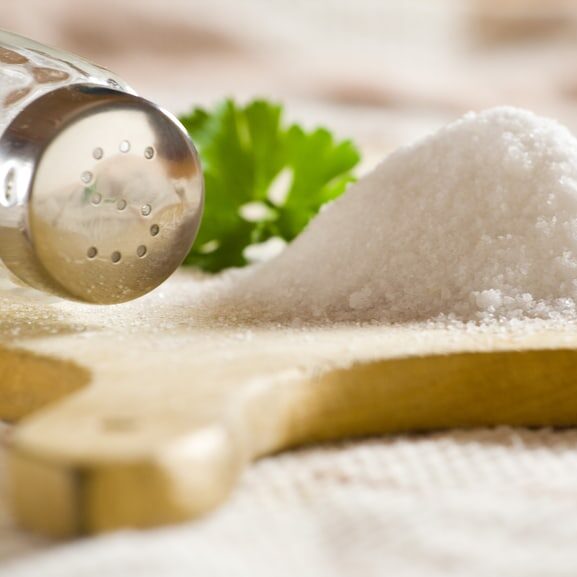 Sea salt on cloth and wooden plate in kitchen.